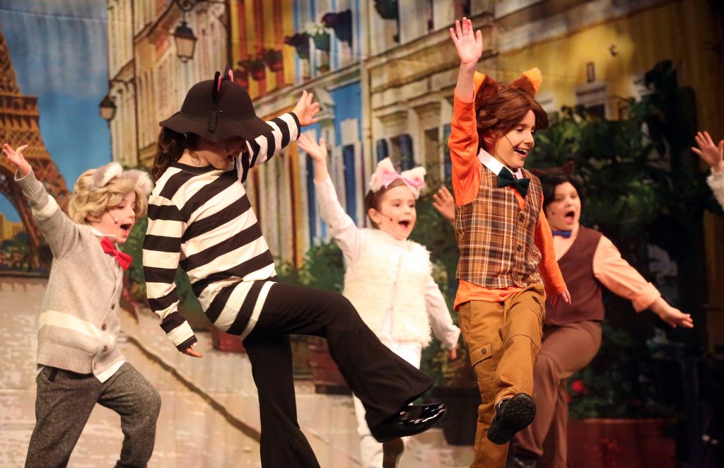 Children on stage performing in Aristocats Kids.