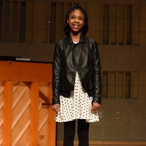 An actress on stage in the spotlight.