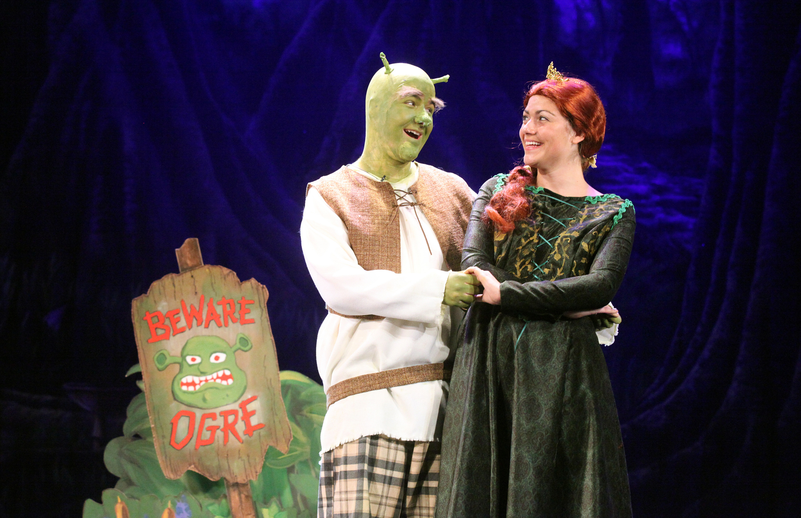 Cast members of Shrek on stage.