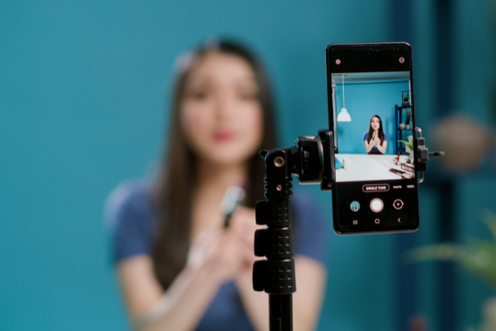 A young student recording themselves via smart phone.