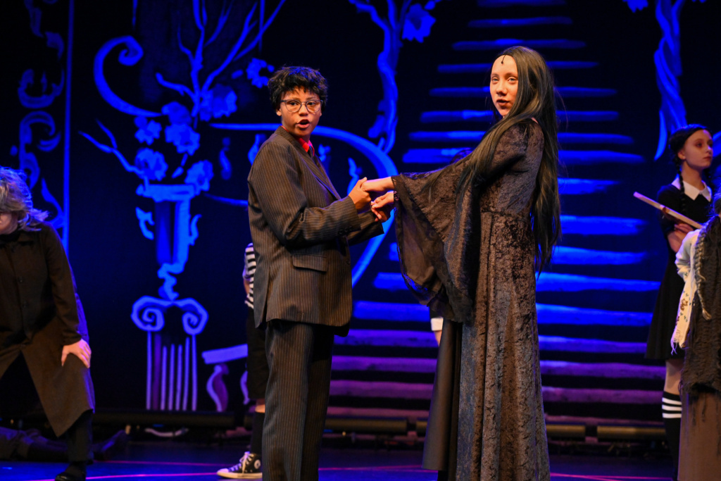 Cast members performing on stage.