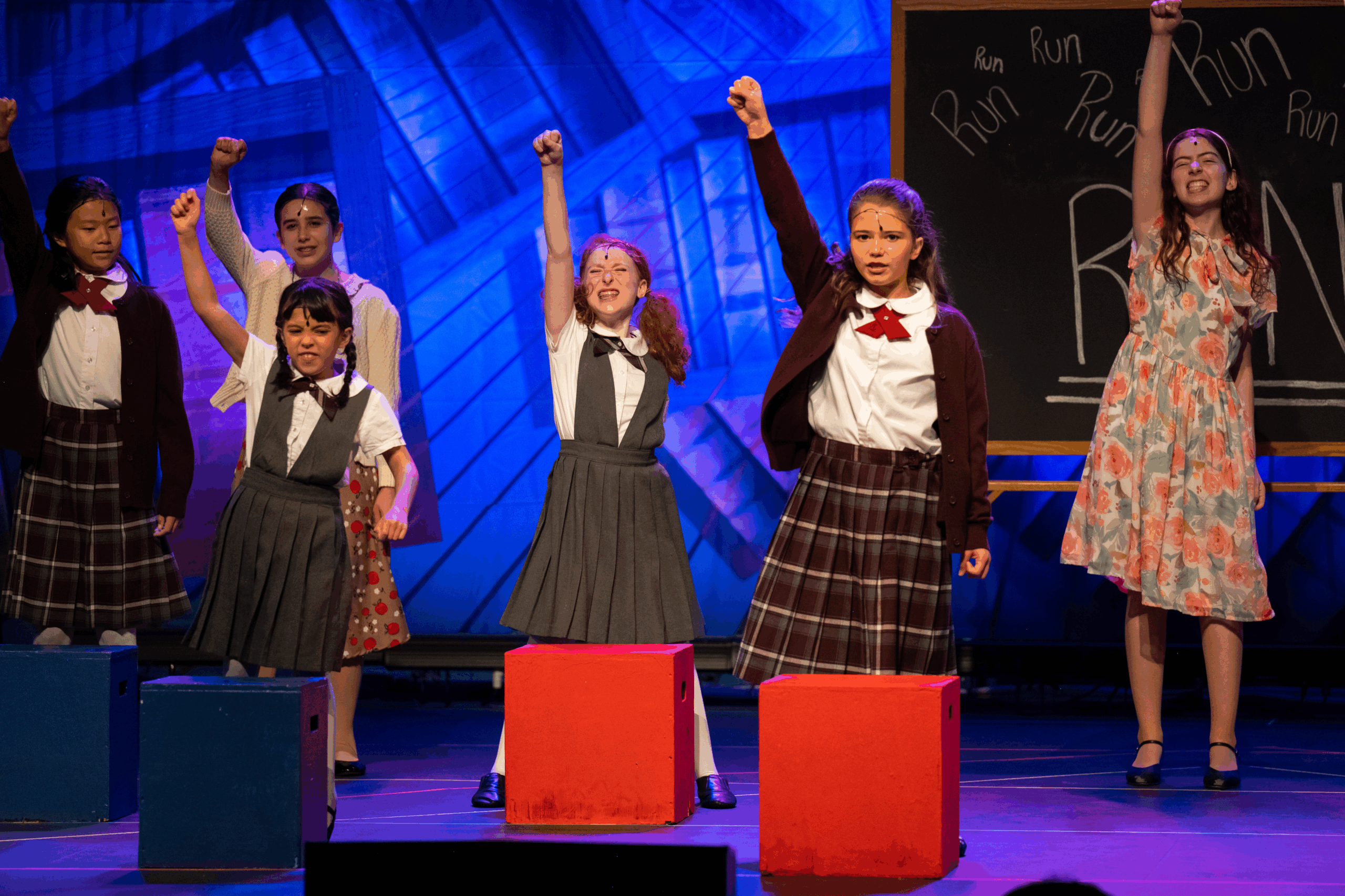 The cast of Matilda performing on stage.